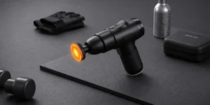 Handheld percussive therapy device with heated attachment and ergonomic grip